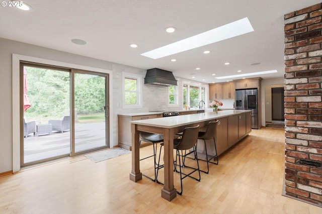18020 SE 370th Ave, Sandy, OR 97055 - kitchen featuring stainless steel refrigerator with ice dispenser, premium range hood, a skylight, light countertops, and recessed lighting