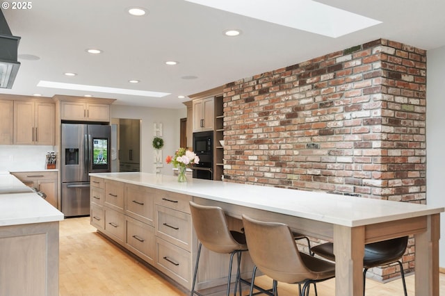 18020 SE 370th Ave, Sandy, OR 97055 - kitchen featuring black appliances, a skylight, recessed lighting, light wood-style flooring, and brick wall