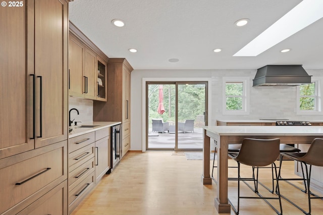 18020 SE 370th Ave, Sandy, OR 97055 - kitchen featuring custom range hood, recessed lighting, tasteful backsplash, a breakfast bar, and light countertops