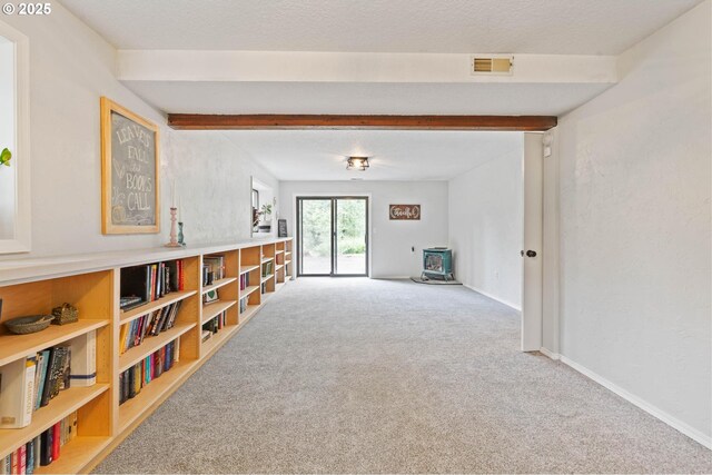 18020 SE 370th Ave, Sandy, OR 97055 - unfurnished living room featuring carpet floors, beamed ceiling, baseboards, and a wood stove