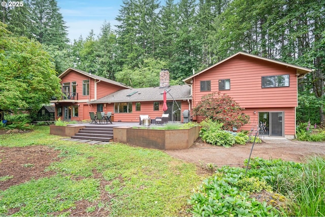 18020 SE 370th Ave, Sandy, OR 97055 - back of house with a chimney, a wooden deck, a patio, and a lawn