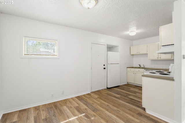 7733 NE Mason St, Portland, OR 97218 - kitchen featuring white appliances, custom range hood, wood finished floors, and a textured ceiling