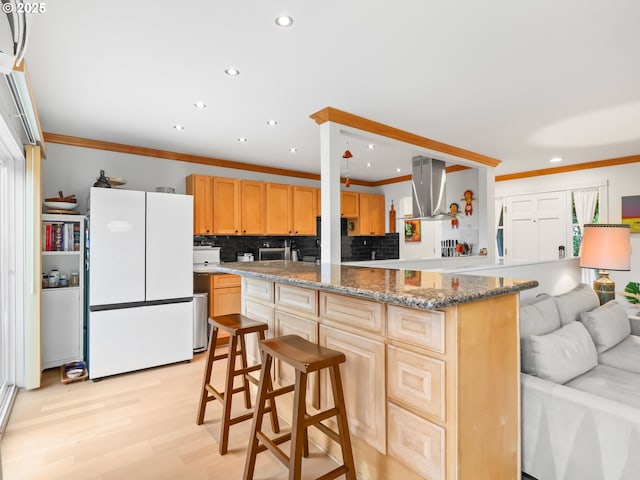 kitchen featuring light wood-type flooring, tasteful backsplash, freestanding refrigerator, crown molding, and extractor fan