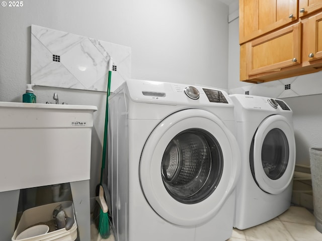 clothes washing area featuring washing machine and clothes dryer and cabinet space