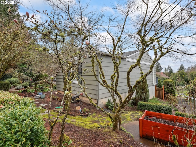 view of side of home featuring a garden