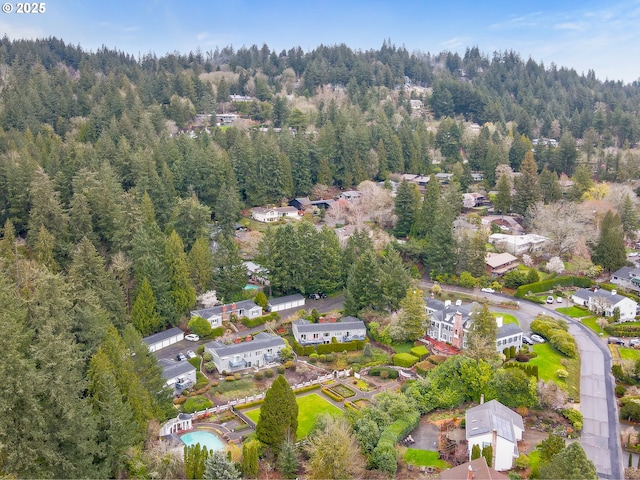 birds eye view of property featuring a forest view