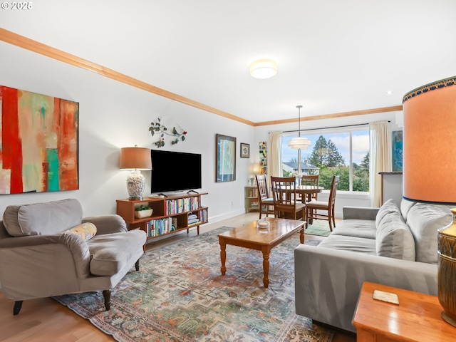 living room featuring crown molding, baseboards, and wood finished floors