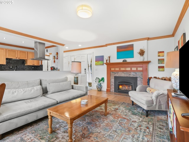 living room featuring recessed lighting, wood finished floors, crown molding, and a tile fireplace