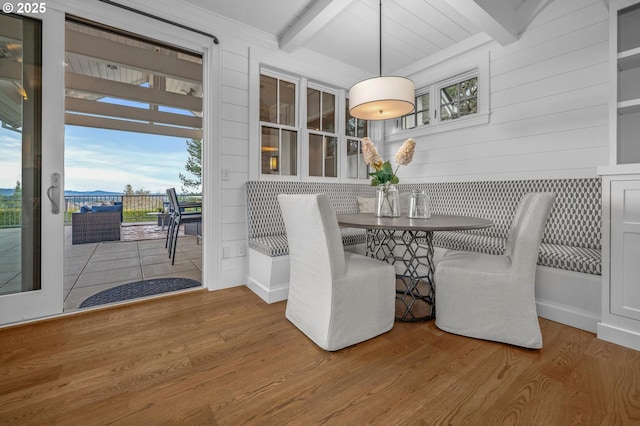 unfurnished dining area with hardwood / wood-style flooring and beamed ceiling