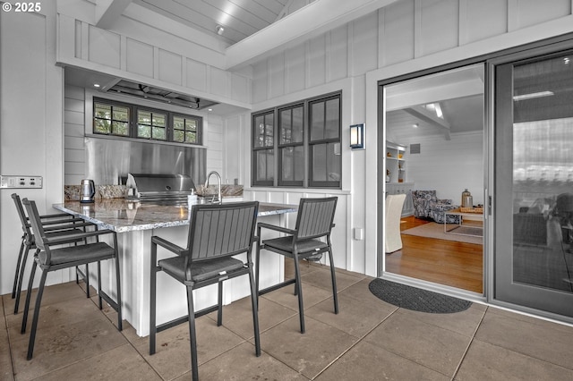 kitchen with tile patterned floors and a kitchen breakfast bar