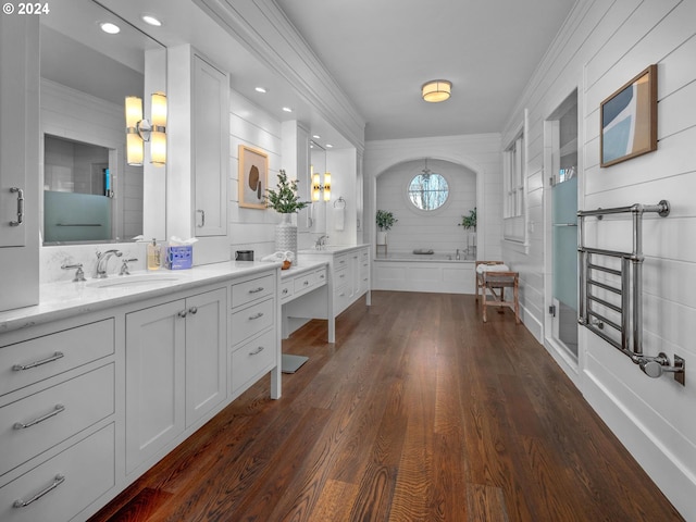 bathroom featuring vanity, hardwood / wood-style floors, a washtub, and backsplash