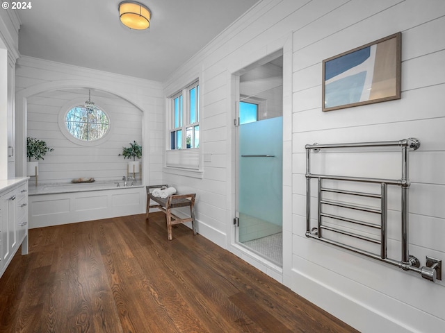 bathroom with ornamental molding, wood-type flooring, and independent shower and bath