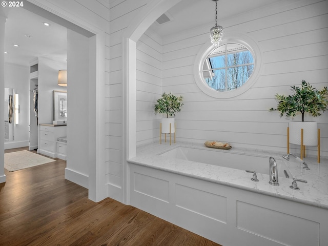 bathroom with hardwood / wood-style floors and a tub