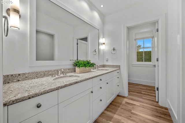 bathroom with vanity, hardwood / wood-style floors, and crown molding