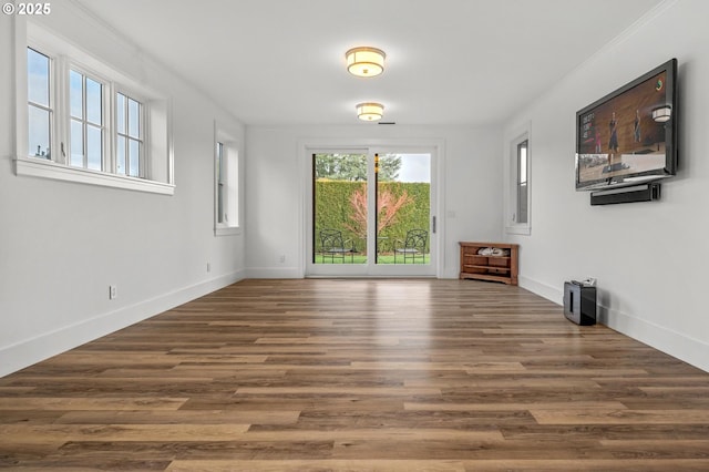 unfurnished living room with ornamental molding and dark hardwood / wood-style flooring