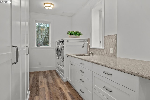 laundry area with washer and dryer, dark hardwood / wood-style floors, sink, cabinets, and ornamental molding