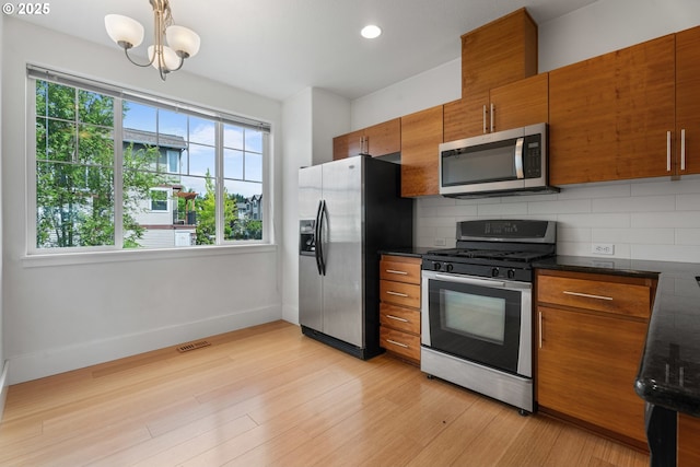 736 NW 118th Ave Unit 102, Portland, OR 97229 - kitchen featuring stainless steel appliances, brown cabinets, decorative backsplash, and recessed lighting