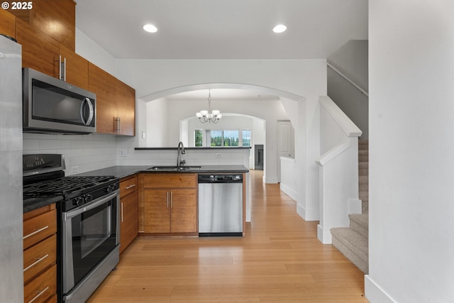 736 NW 118th Ave Unit 102, Portland, OR 97229 - kitchen with appliances with stainless steel finishes, a sink, brown cabinetry, dark countertops, and recessed lighting
