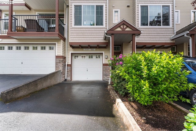 736 NW 118th Ave Unit 102, Portland, OR 97229 - view of front of house featuring stone siding, driveway, and a garage