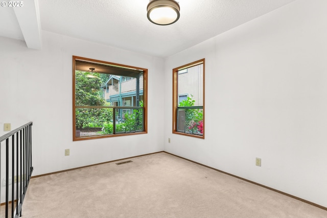 unfurnished room featuring light carpet and baseboards