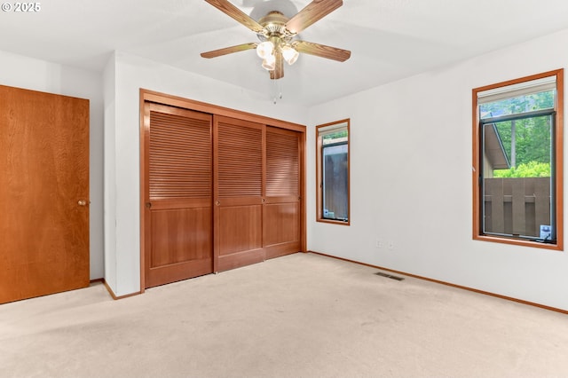 unfurnished bedroom with a closet, carpet floors, baseboards, and ceiling fan