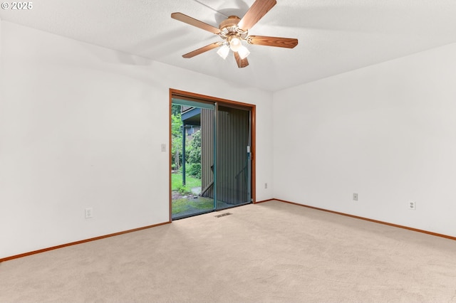 spare room with light colored carpet, baseboards, and ceiling fan