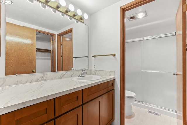full bathroom with a shower stall, toilet, and vanity