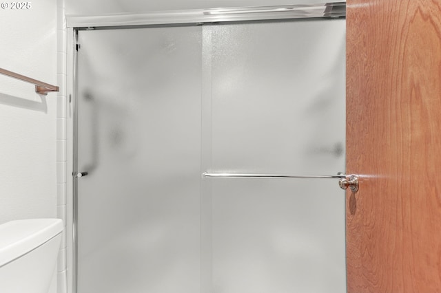 full bathroom with a shower stall and toilet