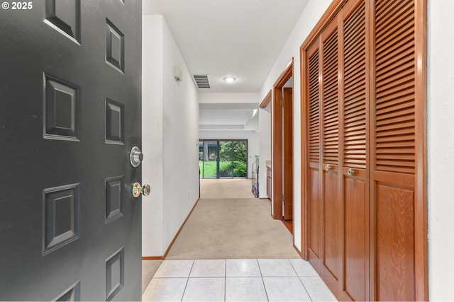 hallway with light colored carpet, light tile patterned floors, and baseboards