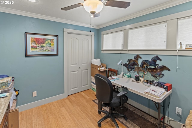 home office with light wood-style floors, ornamental molding, a ceiling fan, and baseboards