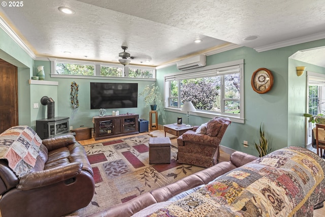 living area with a textured ceiling, a wall unit AC, a wood stove, crown molding, and plenty of natural light