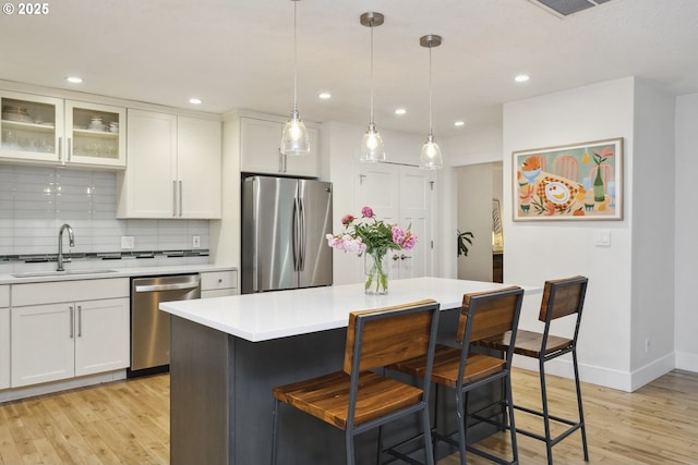 25 SW 143rd Ave, Beaverton, OR 97006 - kitchen featuring stainless steel appliances, a sink, light wood finished floors, light countertops, and white cabinets