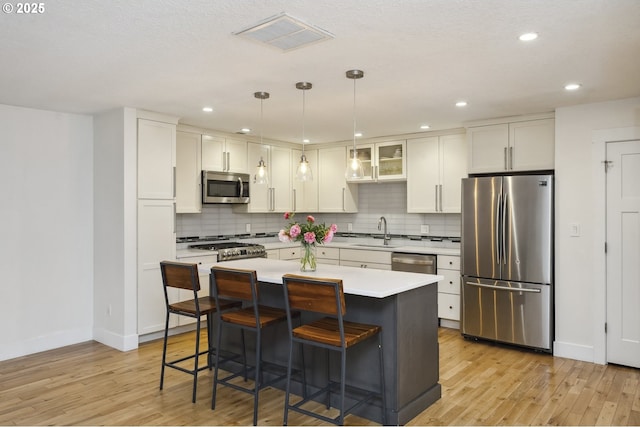 25 SW 143rd Ave, Beaverton, OR 97006 - kitchen featuring stainless steel appliances, a sink, baseboards, light wood finished floors, and recessed lighting