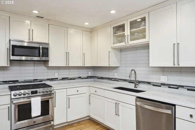 25 SW 143rd Ave, Beaverton, OR 97006 - kitchen featuring stainless steel appliances, a sink, decorative backsplash, light stone countertops, and recessed lighting