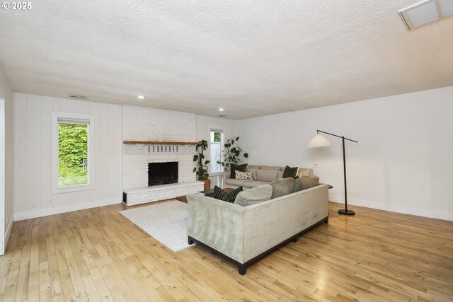 25 SW 143rd Ave, Beaverton, OR 97006 - living area featuring light wood finished floors, baseboards, a textured ceiling, a fireplace, and recessed lighting