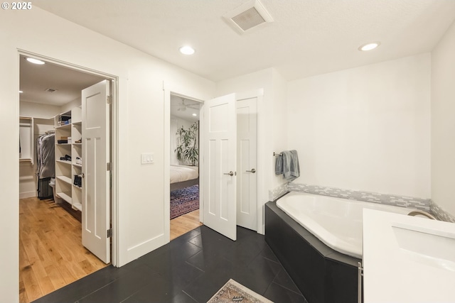 25 SW 143rd Ave, Beaverton, OR 97006 - ensuite bathroom featuring recessed lighting, a walk in closet, a bath, baseboards, and wood finished floors