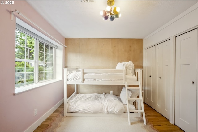25 SW 143rd Ave, Beaverton, OR 97006 - bedroom with wood finished floors, baseboards, multiple closets, and a chandelier