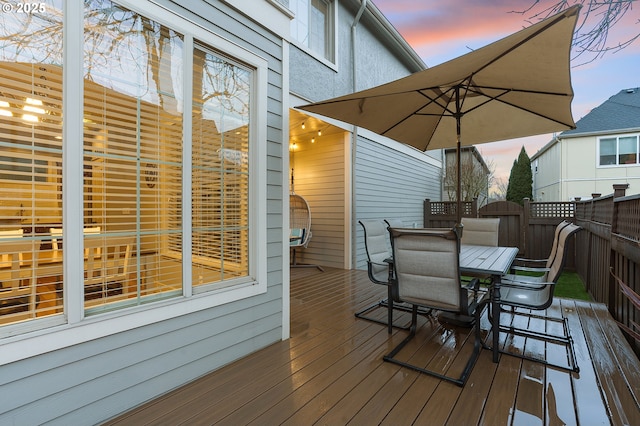 wooden terrace with outdoor dining area and fence