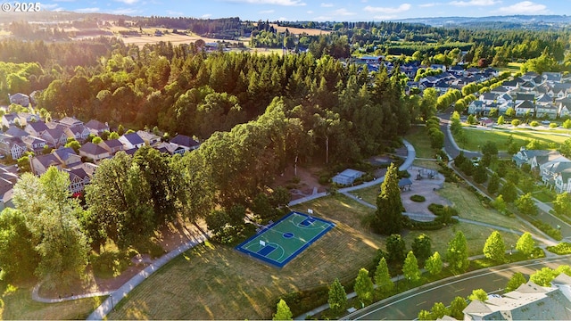 drone / aerial view featuring a residential view and a view of trees