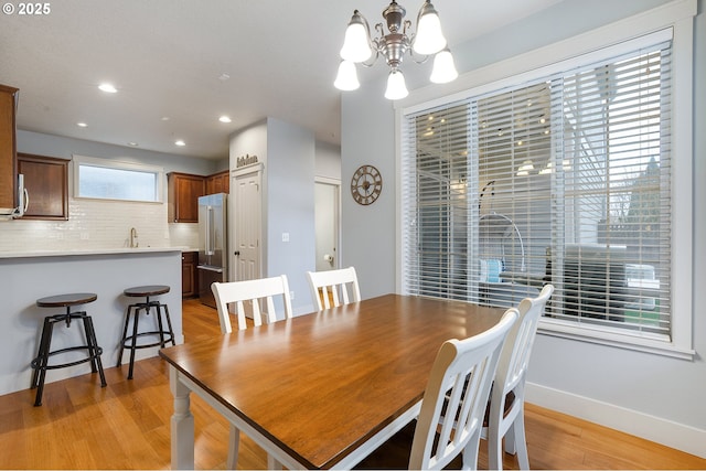 dining room featuring recessed lighting, a notable chandelier, baseboards, and light wood-type flooring