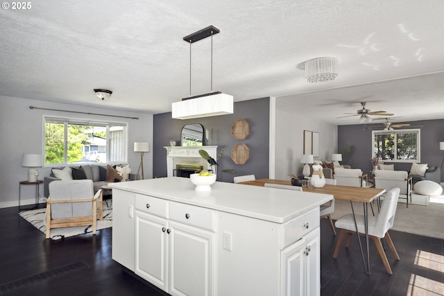2136 SE Kelly Ave, Gresham, OR 97080 - kitchen with open floor plan, a kitchen island, a fireplace, dark wood finished floors, and a textured ceiling