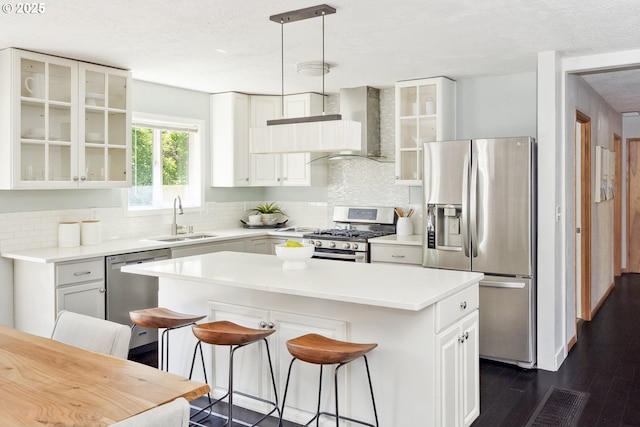 2136 SE Kelly Ave, Gresham, OR 97080 - kitchen with stainless steel appliances, wall chimney exhaust hood, a kitchen island, decorative backsplash, and a kitchen bar