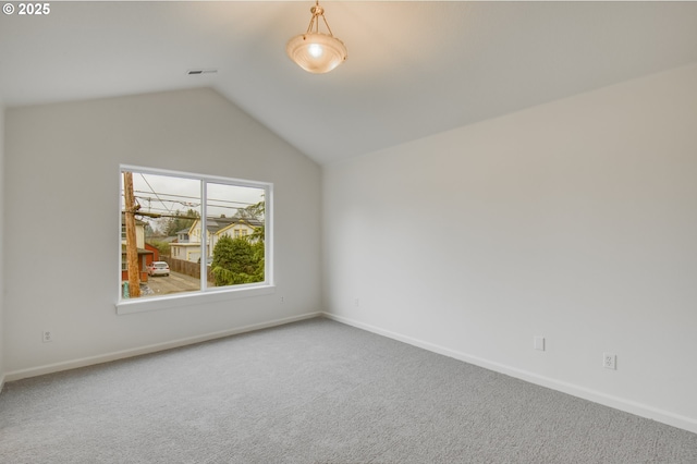 spare room with baseboards, lofted ceiling, and carpet floors