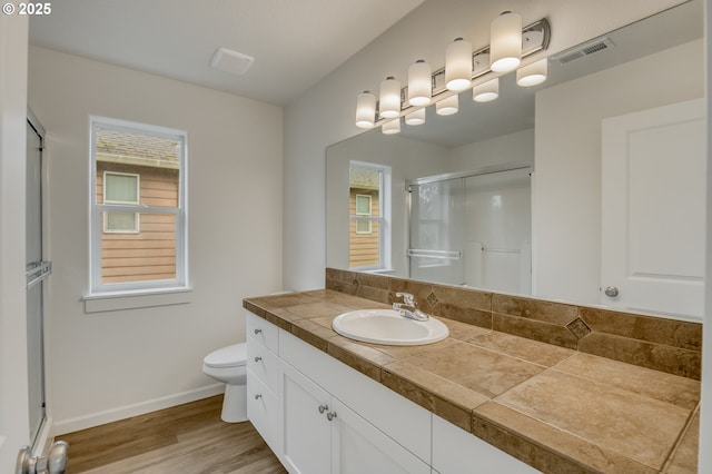 bathroom featuring a wealth of natural light, visible vents, toilet, and a shower stall