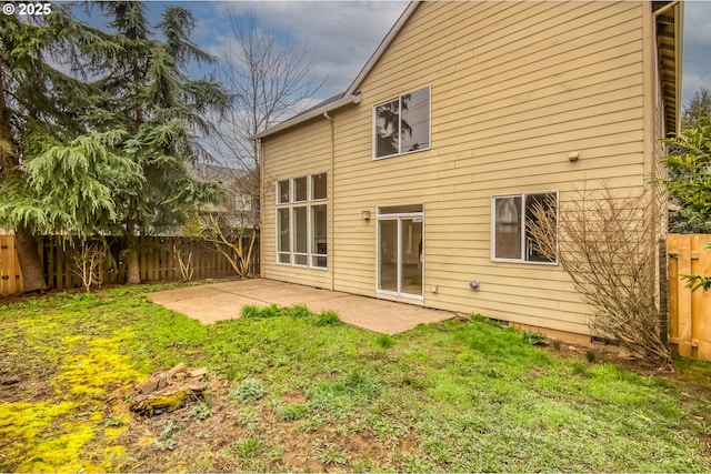 rear view of property featuring a fenced backyard, a lawn, and a patio