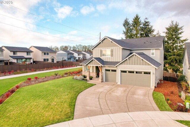 craftsman house featuring an attached garage, fence, concrete driveway, a front lawn, and board and batten siding