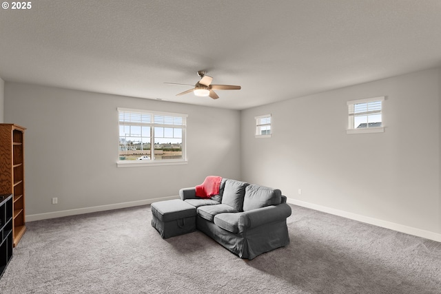 carpeted living room featuring ceiling fan, plenty of natural light, and baseboards