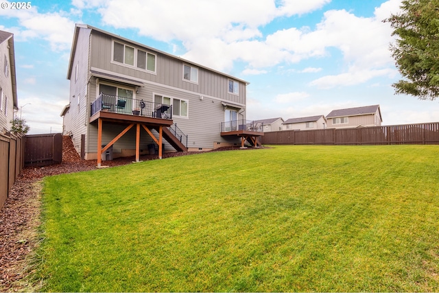 rear view of property with a deck, a fenced backyard, crawl space, stairway, and a lawn