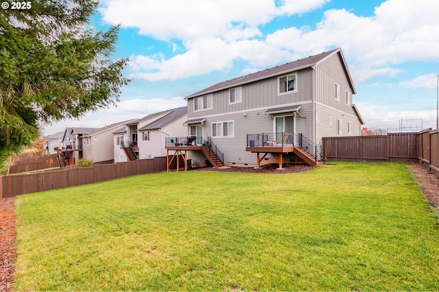 back of house with a deck, stairway, a lawn, and a fenced backyard