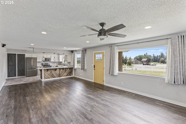 33549 Wikstrom Rd, Scappoose, OR 97056 - unfurnished living room with dark wood-style flooring, recessed lighting, ceiling fan, and a textured ceiling
